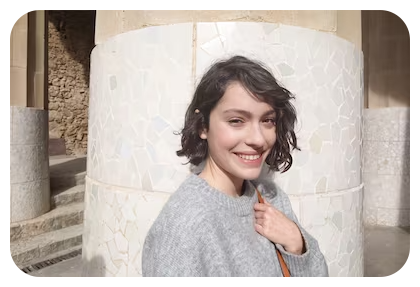 Sony RX0 II sample portrait of woman with short brown hair wearing grey knit jumper standing infront of stone pillar